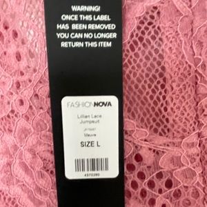 Pink long sleeve lace zip up tie waist jumpsuit.